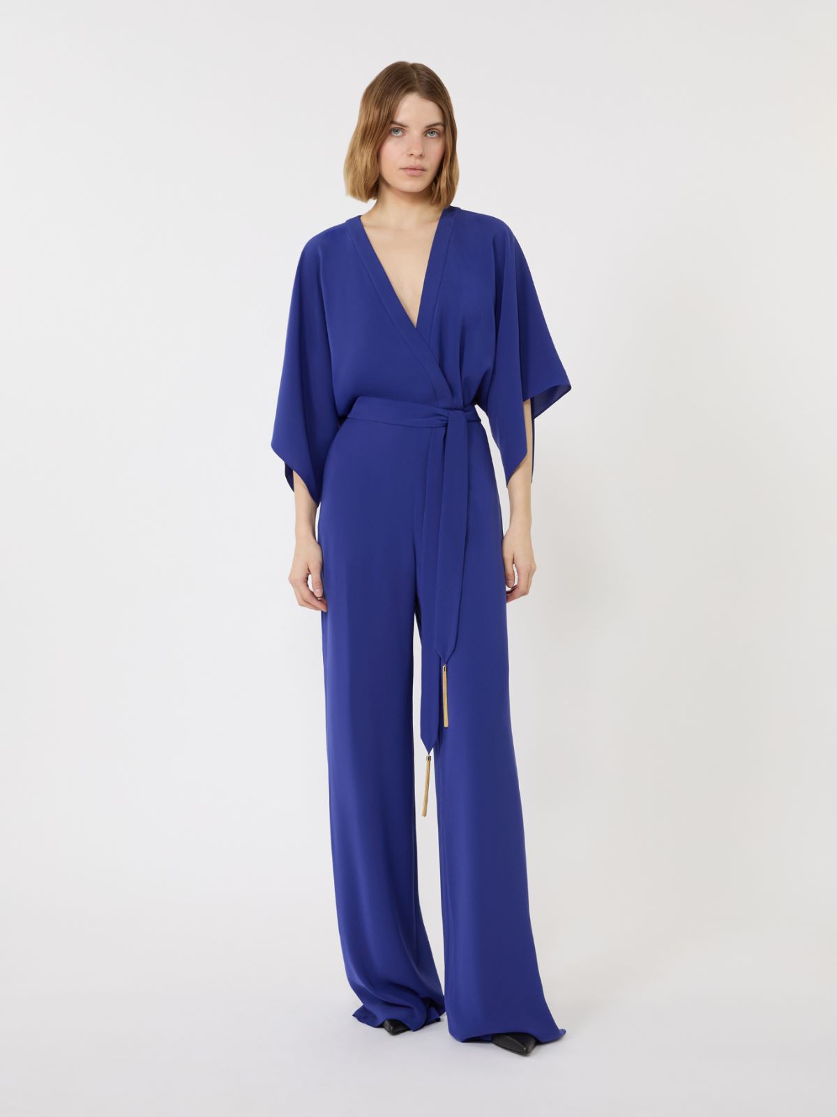 Woman wearing a blue jumpsuit on a white background