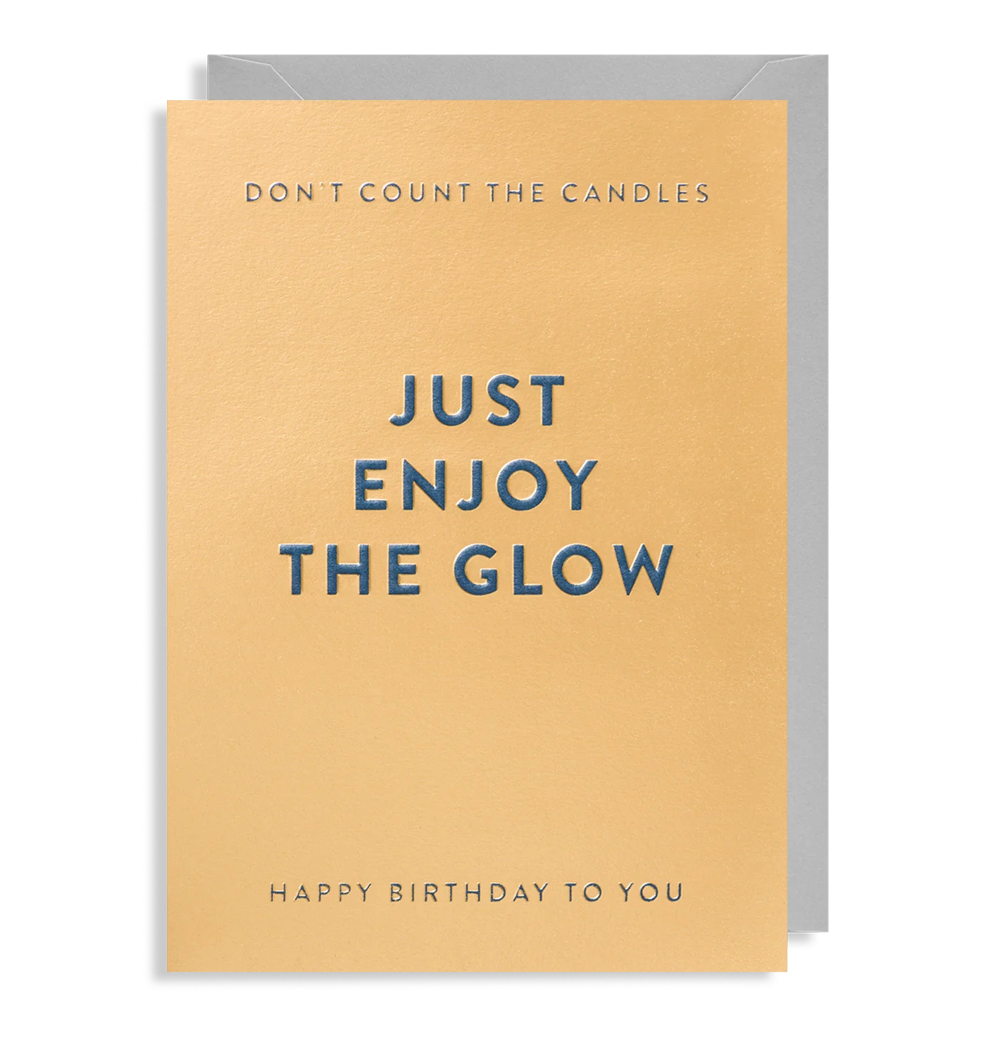 A yellow birthday card with blue embossed text that reads 'Don't count the candles, just enjoy the glow. Happy Birthday to you.