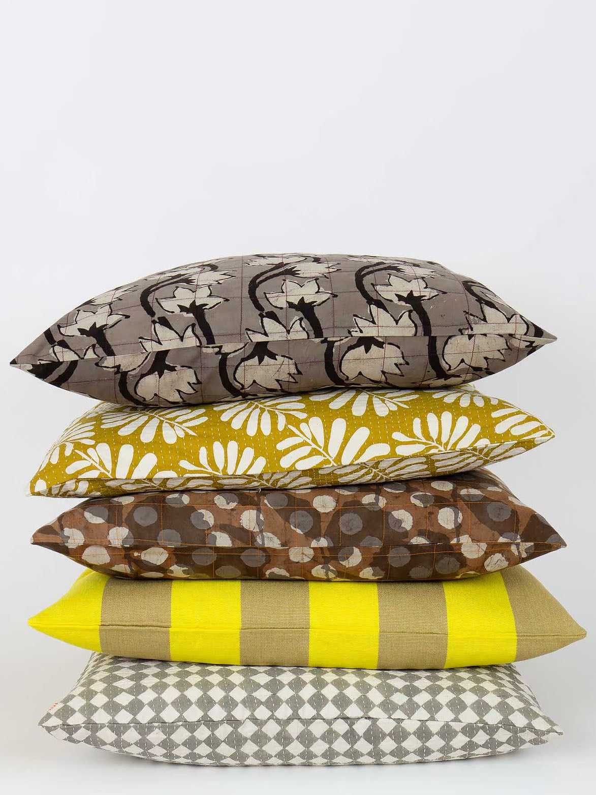 Stack of patterned pillows on a white background