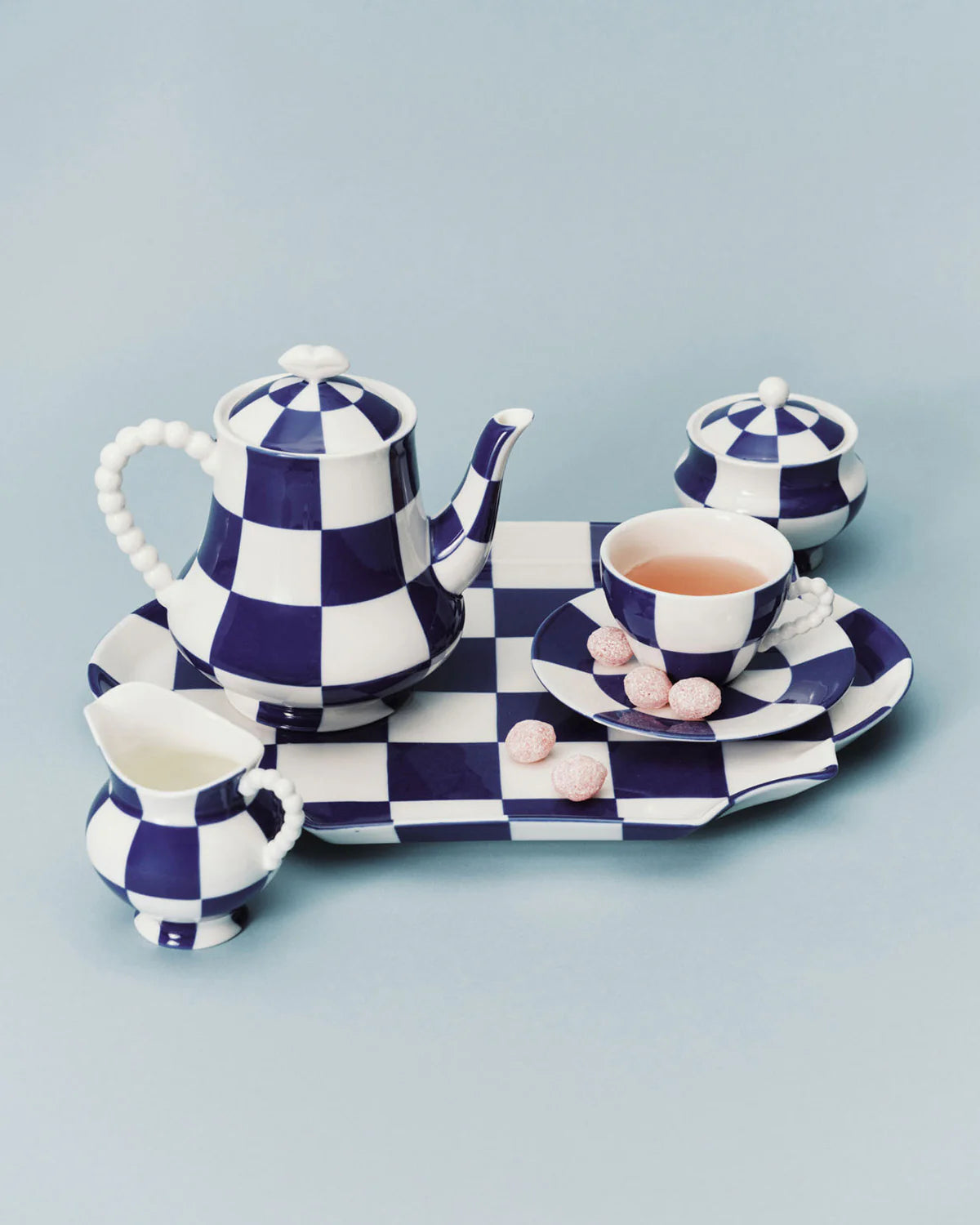 Blue and white checkered tea set on a light blue background