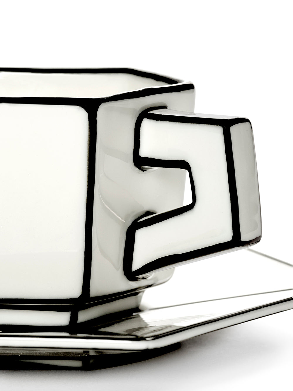 Ceramic espresso mug and saucer with geometric design on a white background
