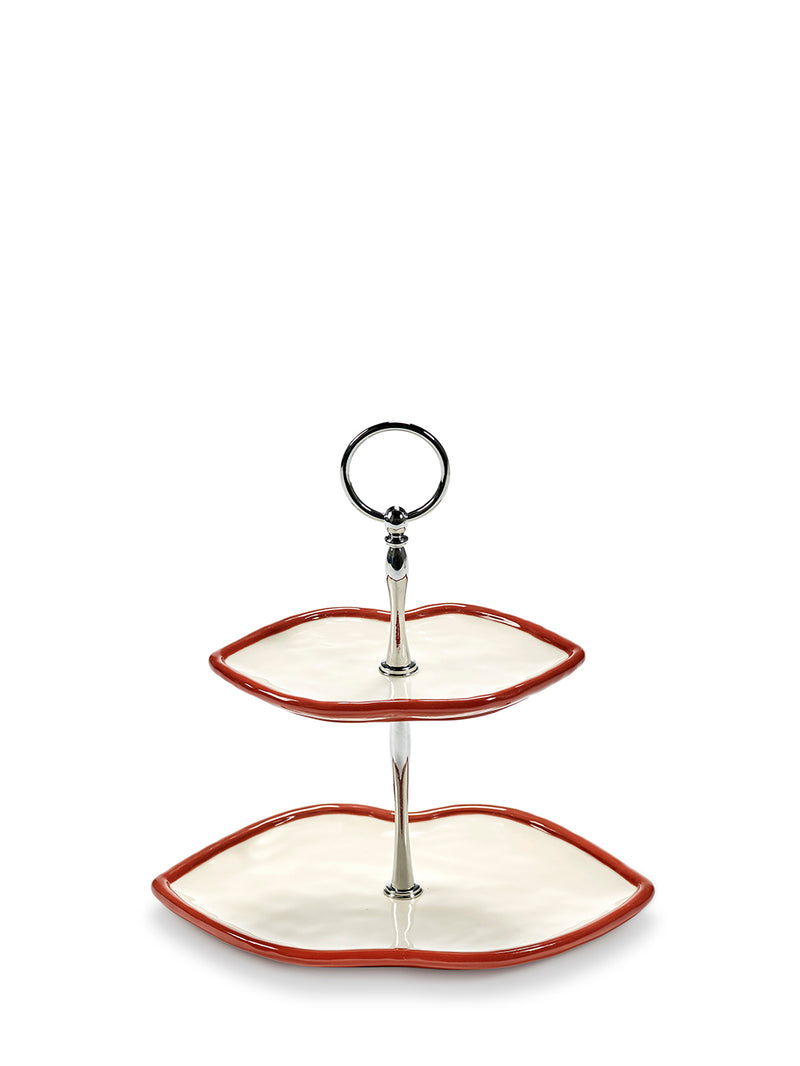 Two-tiered ceramic serving tray in shape of lips with a metal handle on a white background
