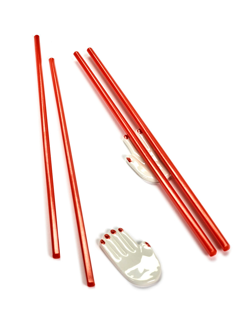 Red chopsticks with a white hand-shaped object on a white background