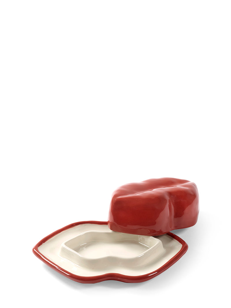 Red ceramic dish with a white interior on a white background