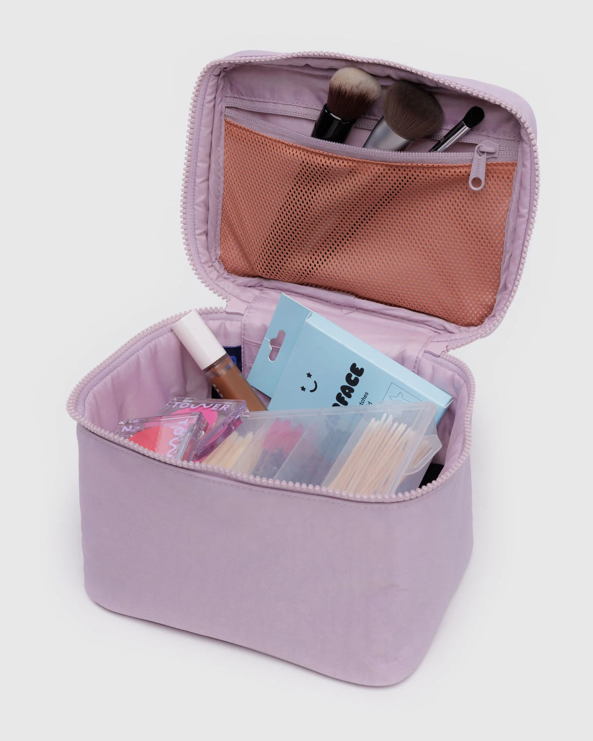 Dusty pink makeup bag with cosmetic items on a light gray background
