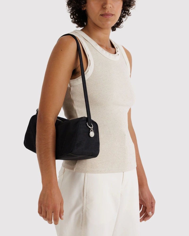 Woman wearing a black shoulder bag on a white background