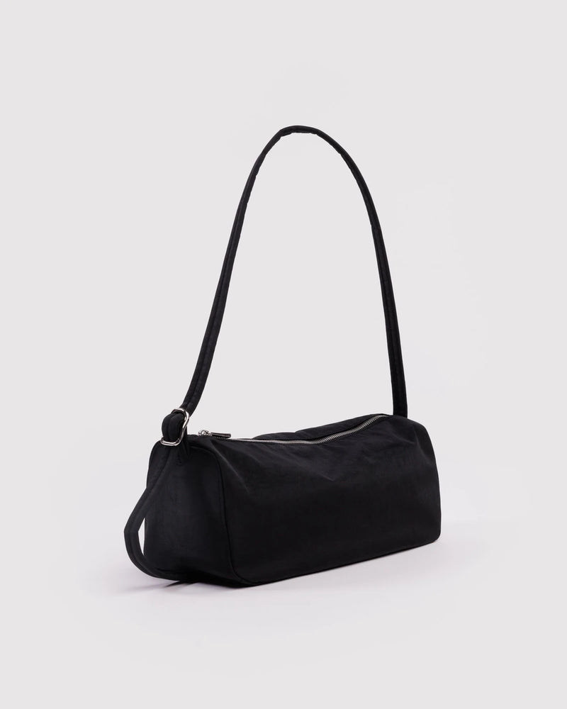 Black handbag with a strap on a light gray background