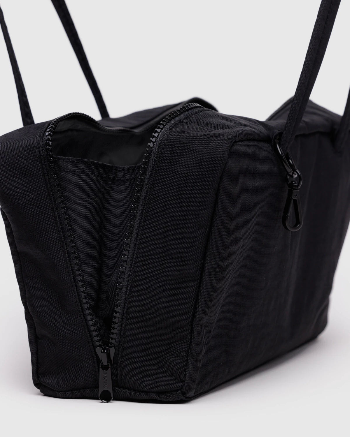 Black duffel bag with straps on a light gray background