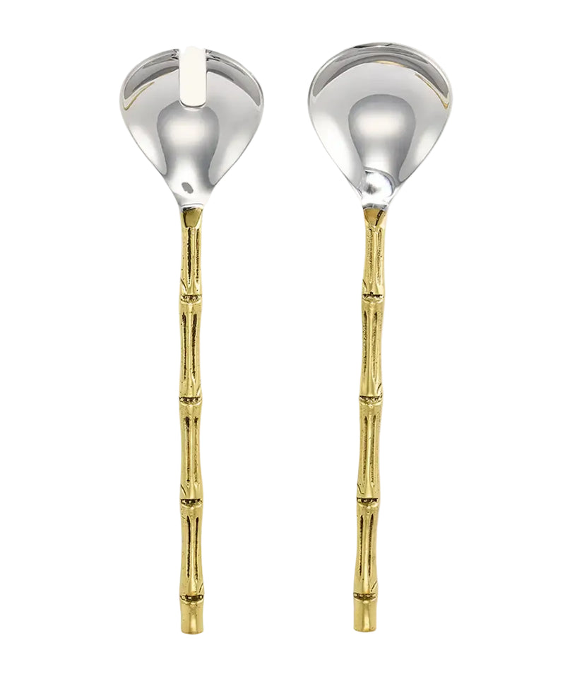 Two salad spoons with metallic silver bowls and gold-toned bamboo-style handles, shown side by side on a light cream background.