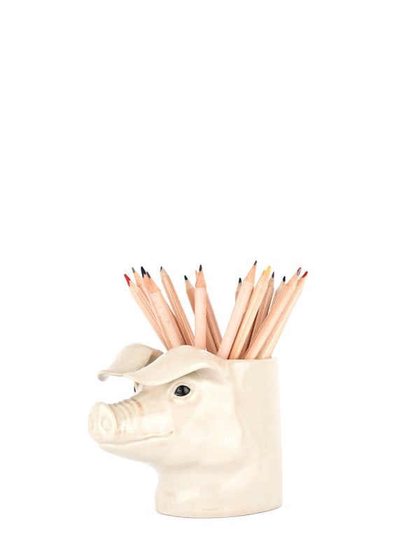 Pig-shaped pencil holder with colored pencils on a white background