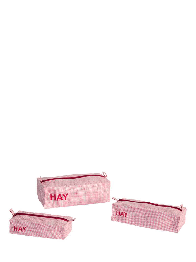 Three light pink patterned zippered pouches with red trim and the word 'HAY' printed in red on the front, arranged on a plain white background.