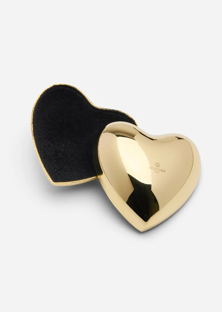 Gold heart-shaped compact mirror with black interior on a white background