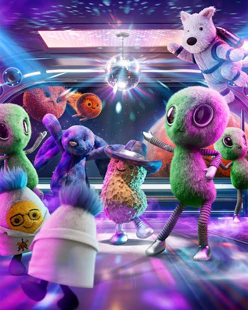 Colorful plush toys in a disco setting with a mirror ball and vibrant lights.
