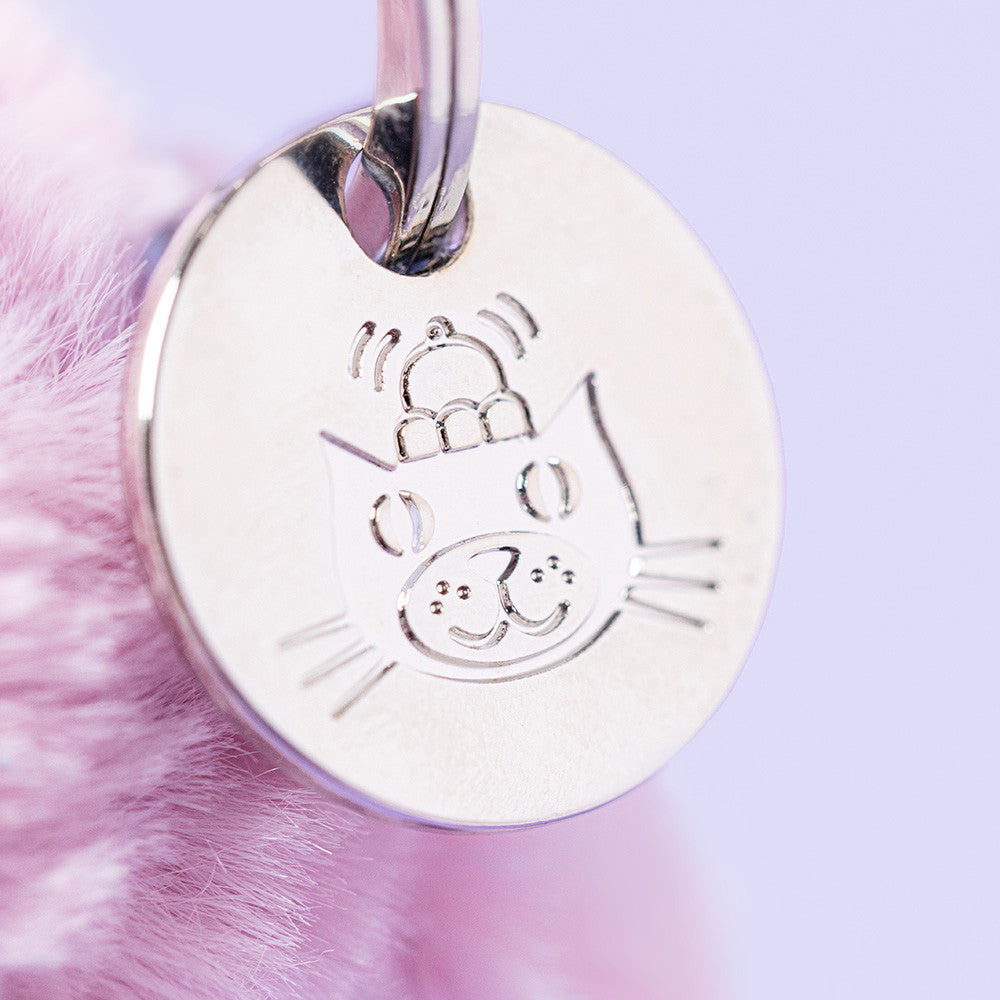 Silver cat-shaped pendant on a pink fluffy background