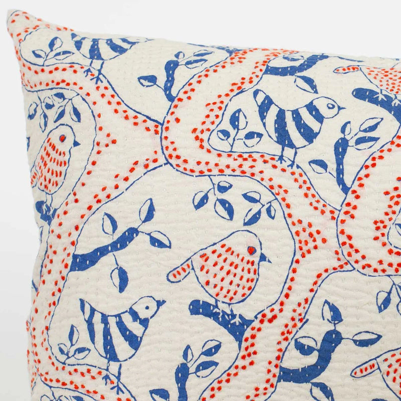 Decorative pillow with blue and red bird pattern on a white background