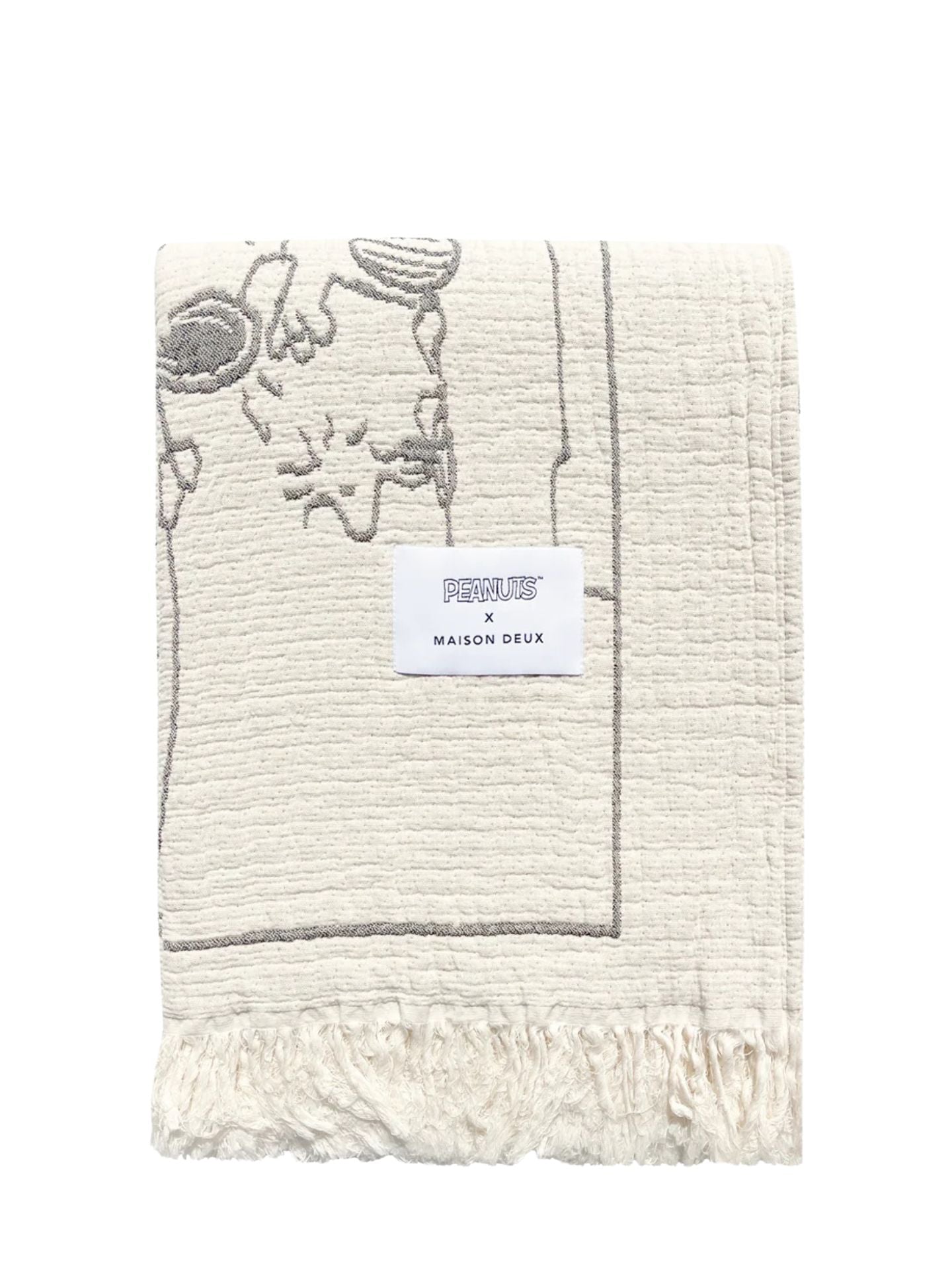 Textured blanket with fringe and a label on a white background
