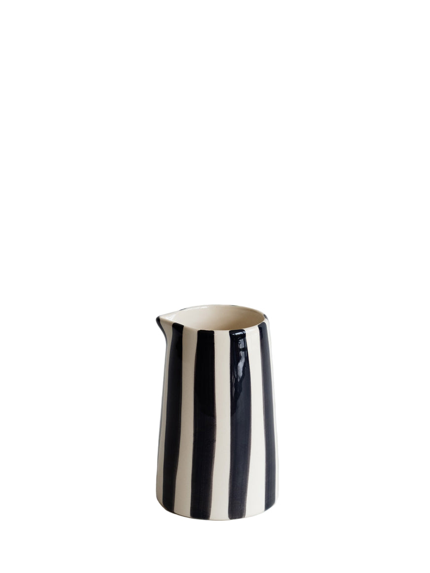 Black and white striped ceramic pitcher on a light gray background