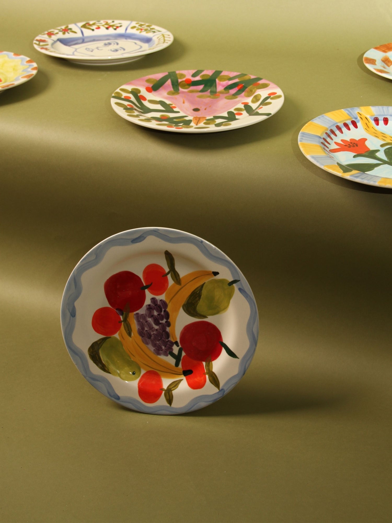 Decorative plates with fruit designs on a green background