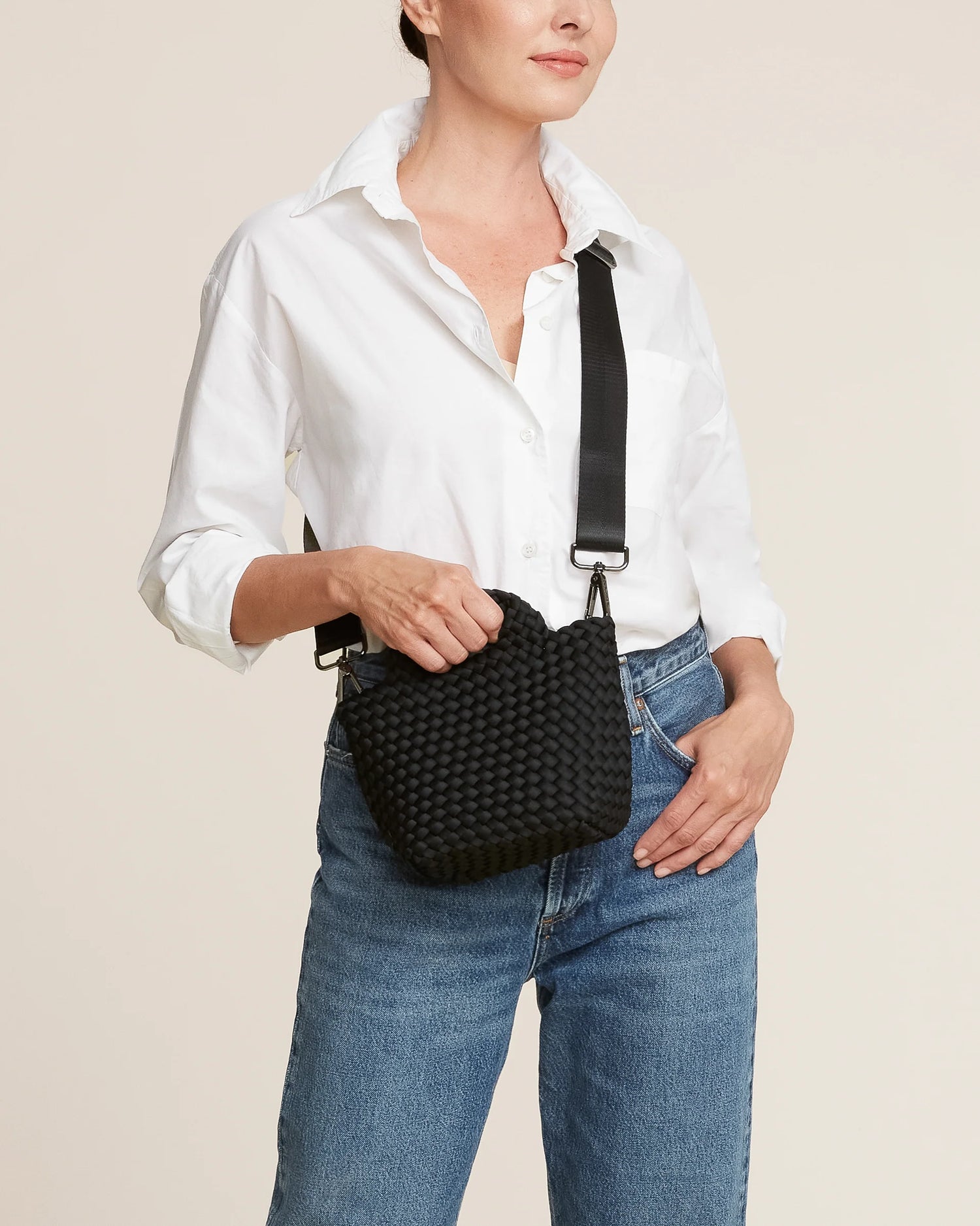 Woman holding a black woven handbag by Naghedi 