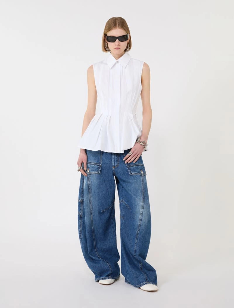 Person wearing a white sleeveless top and blue jeans on a white background