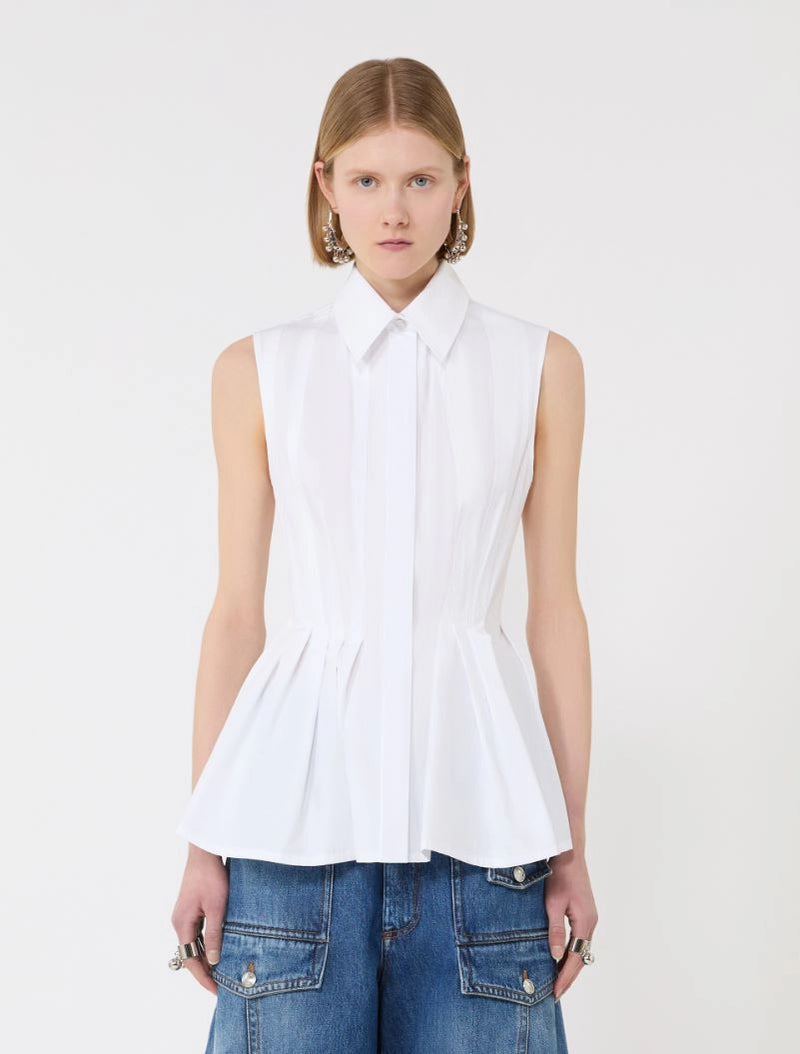 Woman wearing a white sleeveless blouse with a collar on a plain background