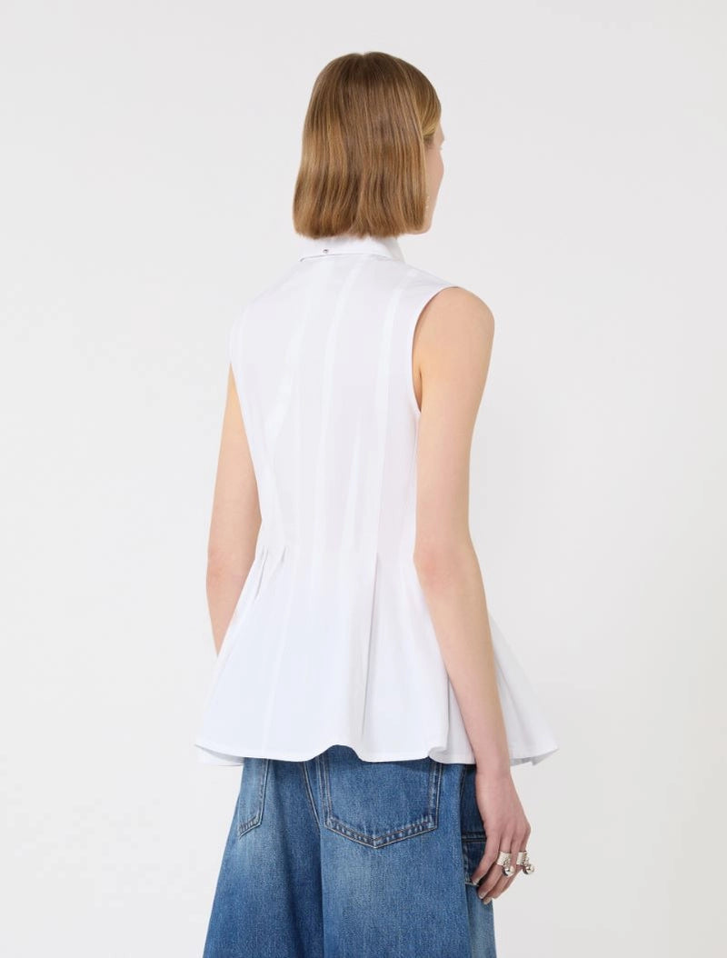 Person wearing a white sleeveless top and blue jeans on a plain background