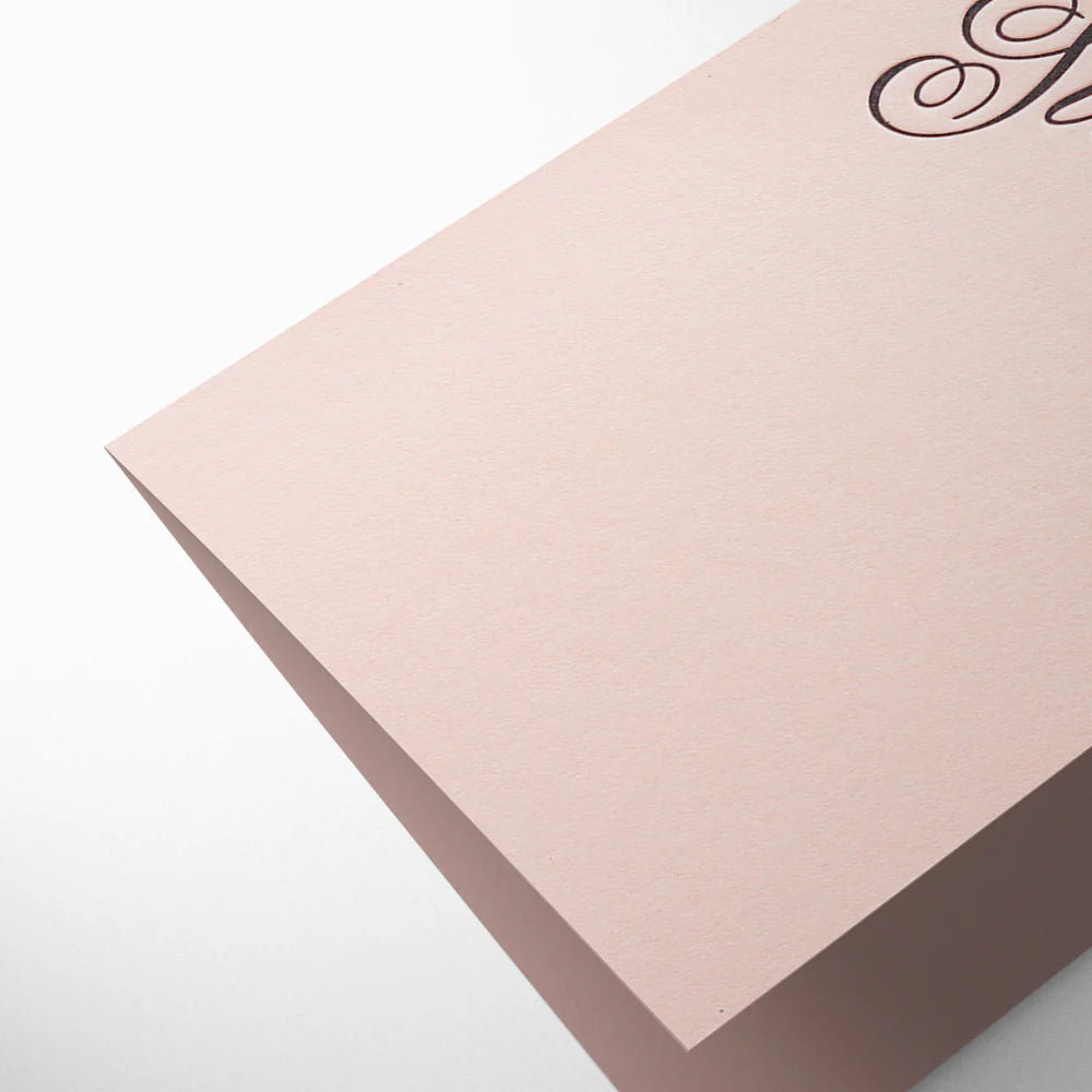 Pink card with decorative text on a light gray background