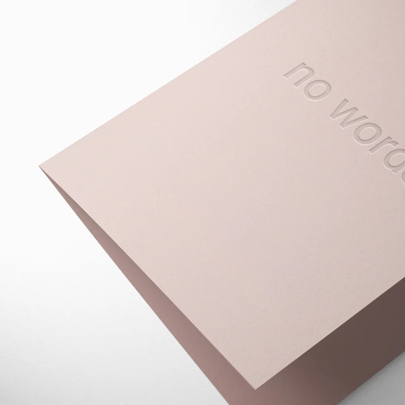 Pink greeting card with 'no word' embossed on it on a white background