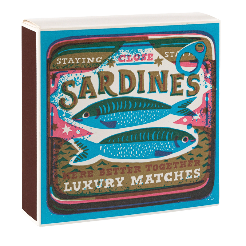 Matchbox with sardine design and text 'Staying Close Sardines Were Better Together Luxury Matches' on a white background
