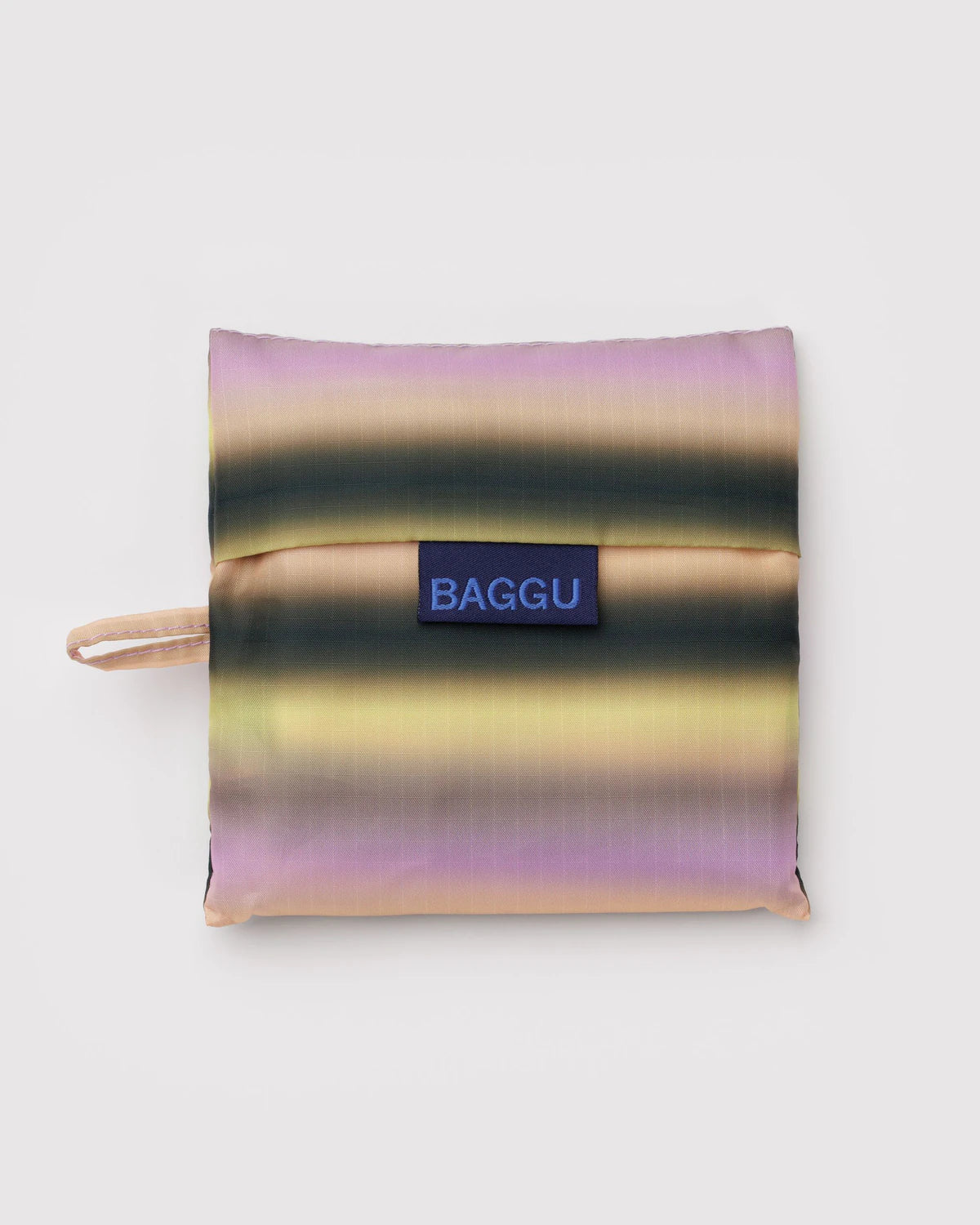 Foldable shopping bag with gradient pattern and 'BAGGU' logo on a light gray background