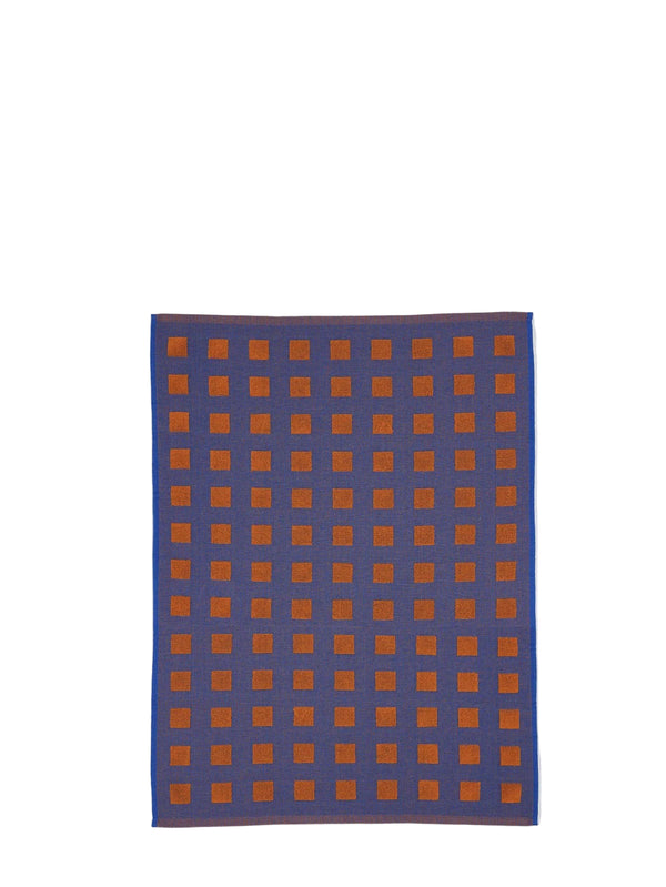 A rectangular woven textile with a blue base and a grid pattern of orange squares, displayed against a light gray background.