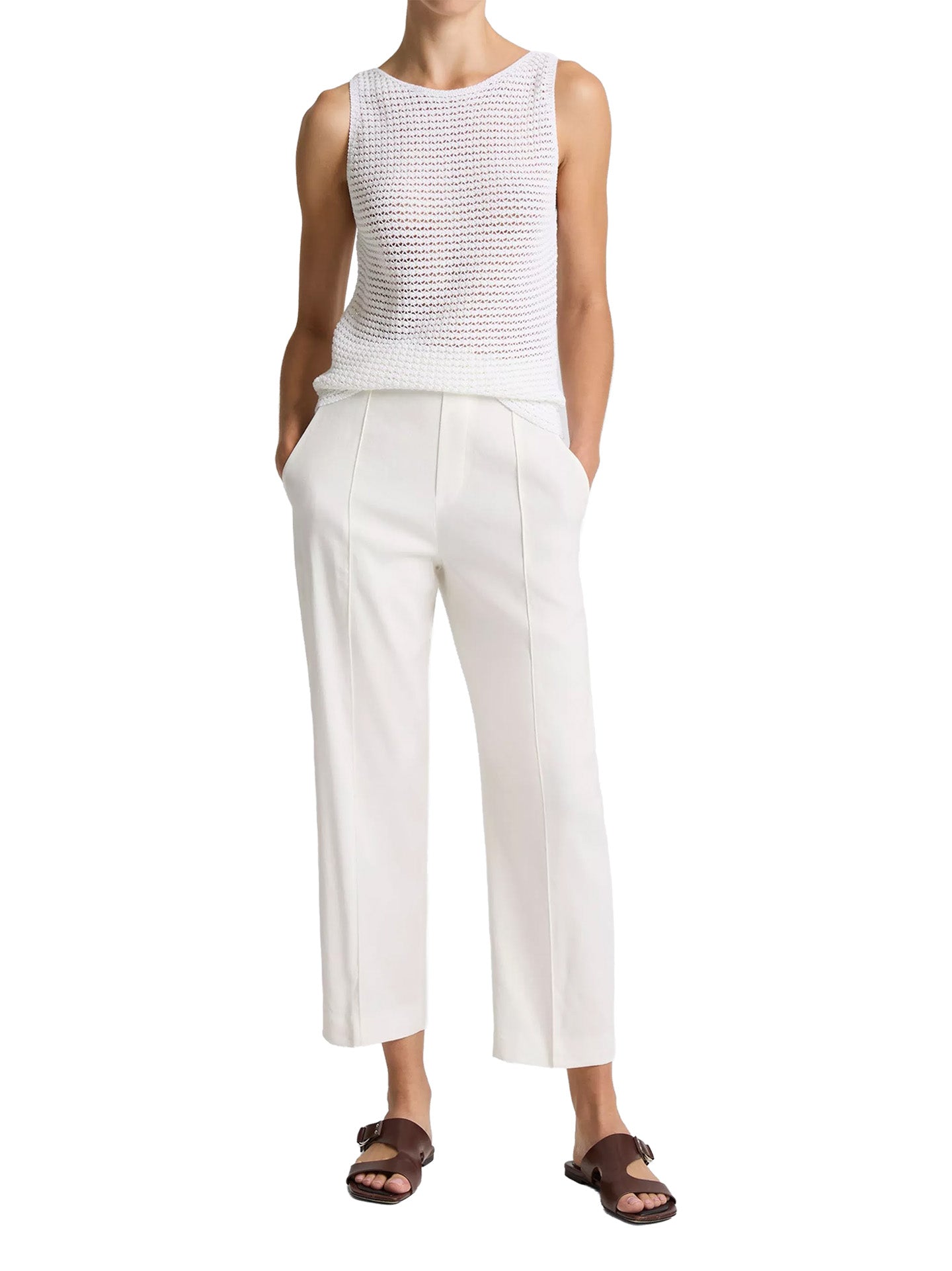 Person wearing a white sleeveless top and pants on a white background