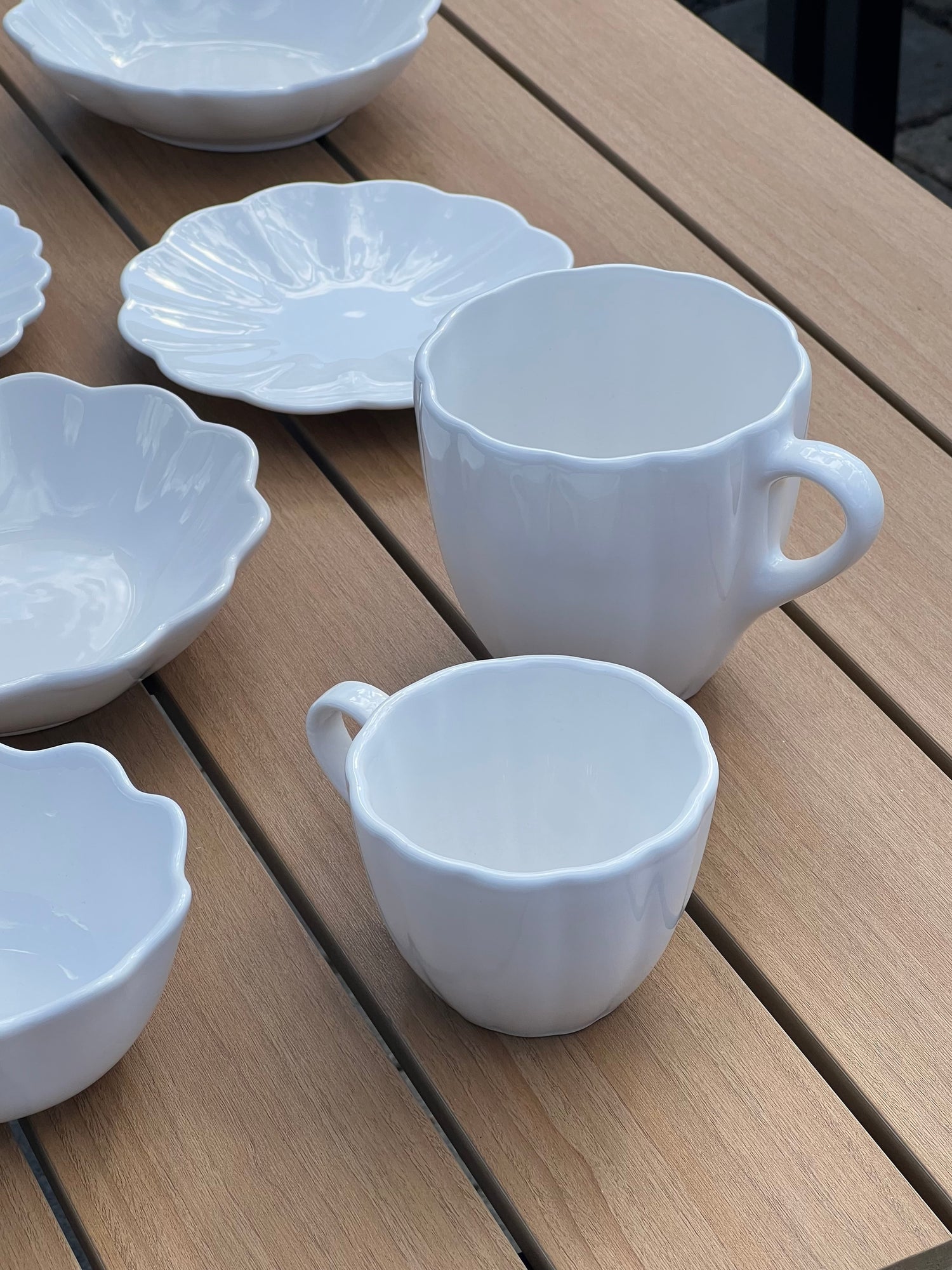 White ceramic cups and saucers on a wooden surface