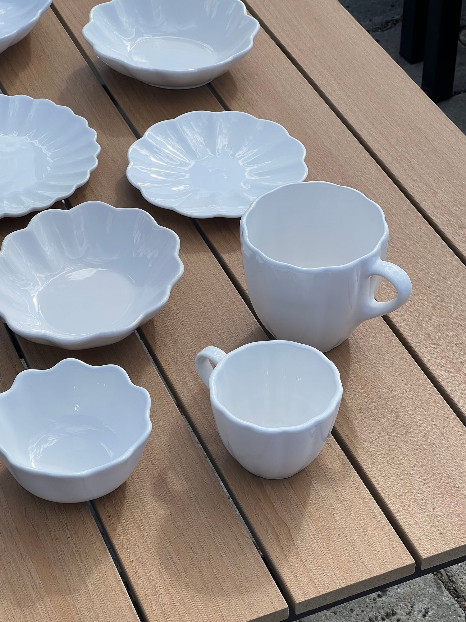 White ceramic cups and saucers on a wooden surface