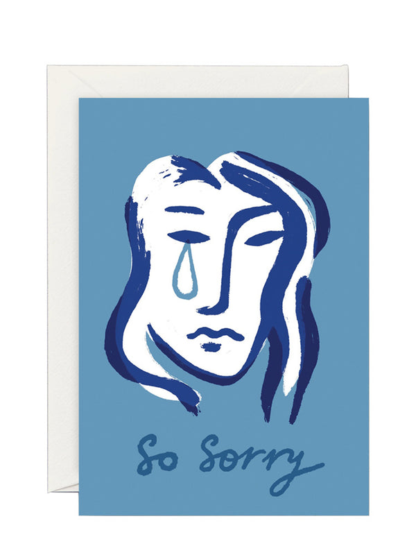 A blue card with an illustration of a teardrop-shaped face with a single tear, accompanied by the text 'So sorry' on the bottom. It has a light cream envelope.