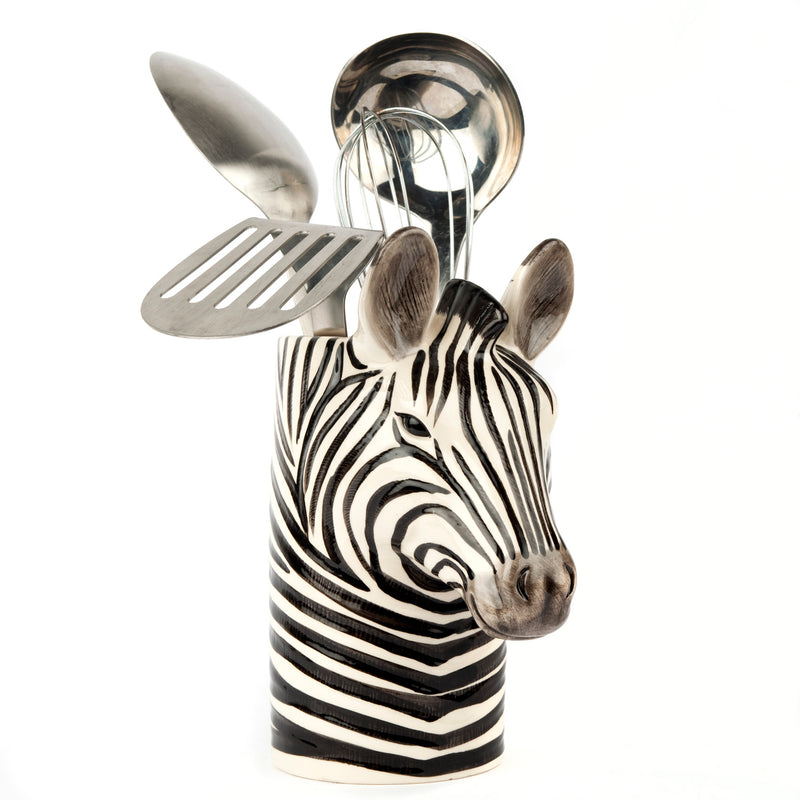 Zebra-shaped kitchen utensil holder with utensils on a white background