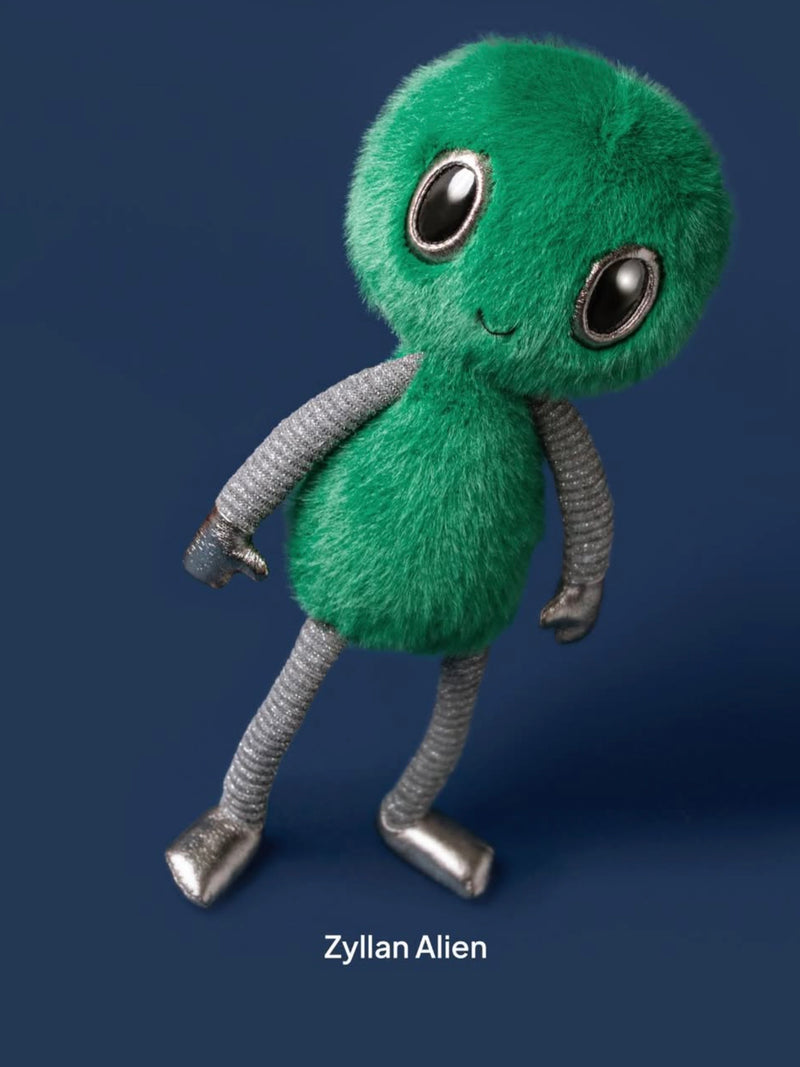 Green alien plush toy with gray limbs on a dark blue background
