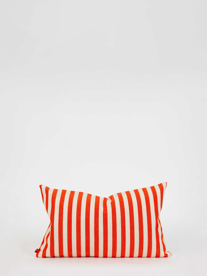Orange and white striped pillow on a light gray background