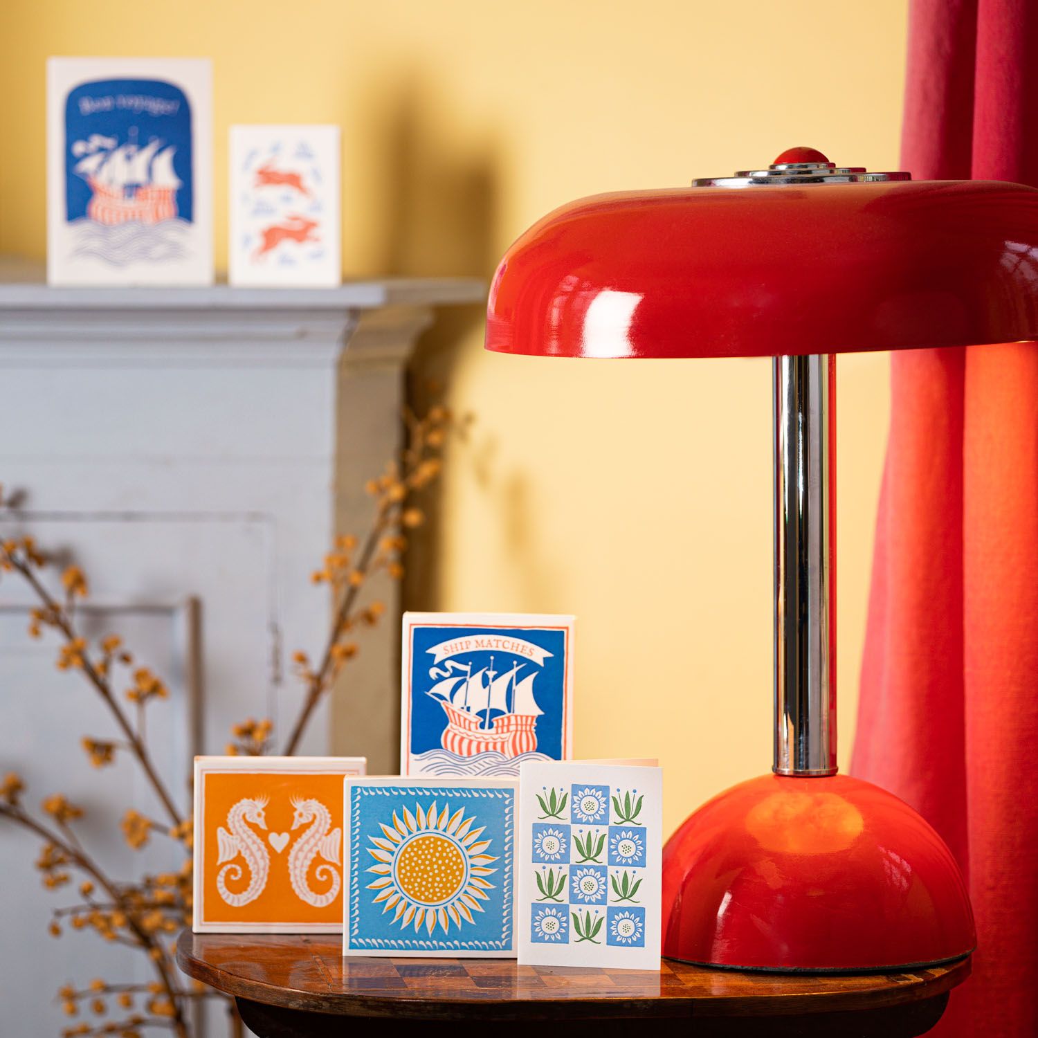 Red lamp on a table with decorative cards and a blurred background
