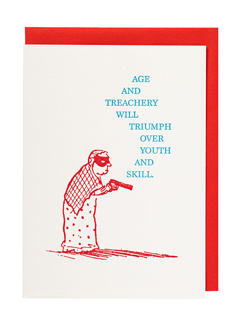 A greeting card with an off-white front featuring a red illustration of a masked granny in a nightie, shawl and a cap, holding a gun with both hands and blue text that reads, 'AGE AND TREACHERY WILL TRIUMPH OVER YOUTH AND SKILL.' A red envelope is visible behind the card on a white background.