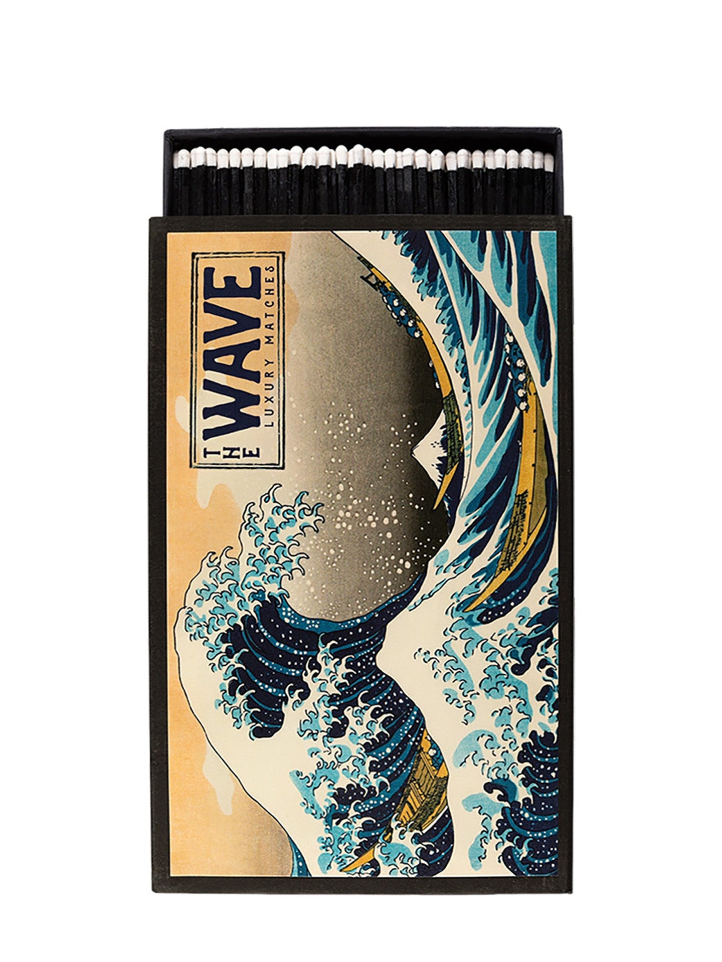 A matchbox-style novelty match box featuring the iconic Japanese wave illustration, and black matches visible inside. The front reads 'WAVE LUXURY MATCHES' and shows blue, beige, white, and black tones.