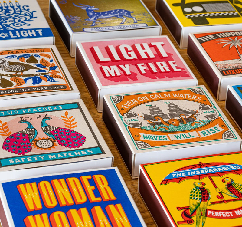 Collection of colorful matchboxes with various designs and text.