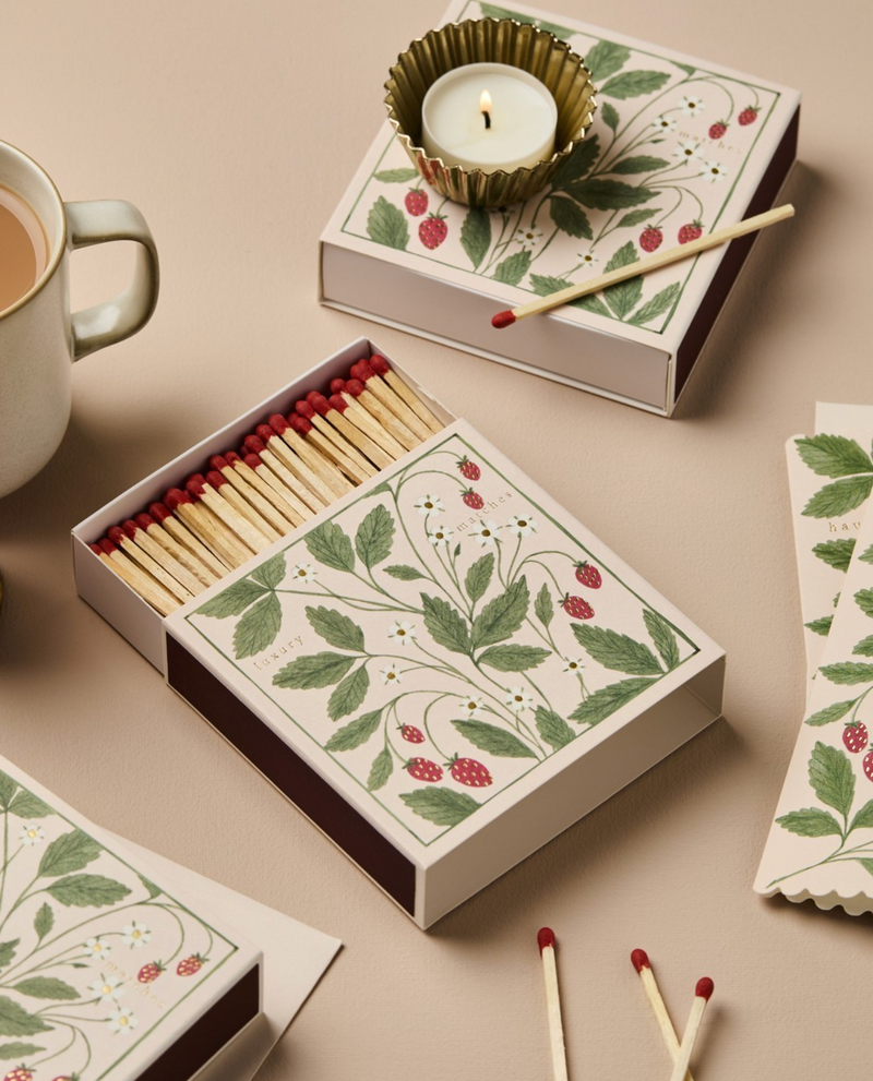 Matches with decorative box featuring floral design on a beige surface.