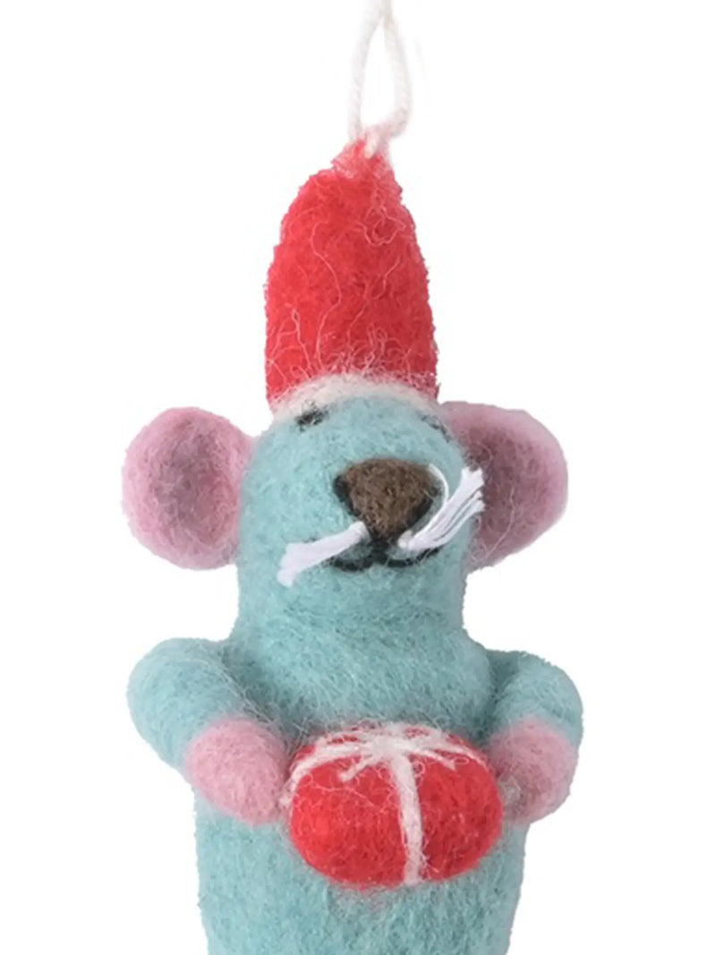 A felt mouse ornament in light blue with pink ears and paws, wearing a red hat and holding a red gift box, shown in close-up against a plain white background.