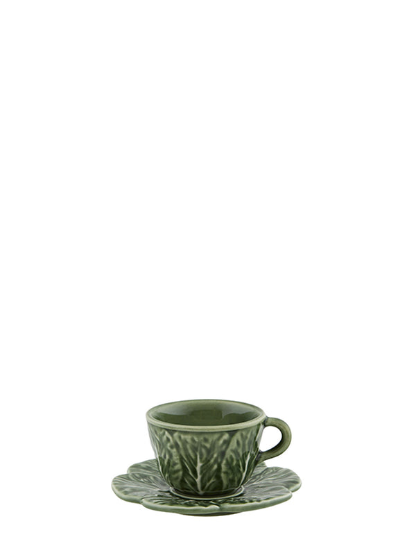 Green ceramic cup and saucer with cabbage leaves pattern on a white background