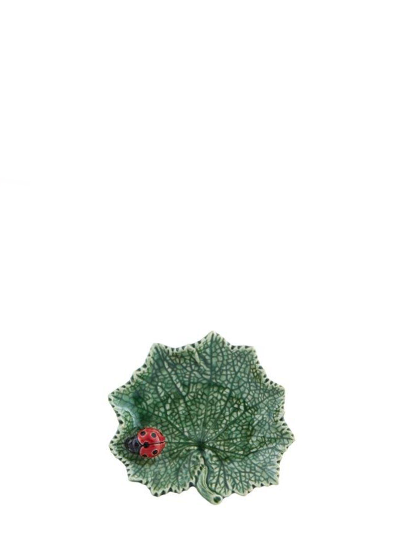 A small green leaf-shaped ceramic serving platter with a red ladybug detail on the lower right side.