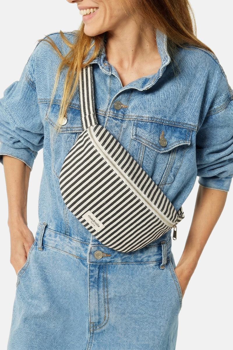 Person wearing a striped fanny bag and denim outfit