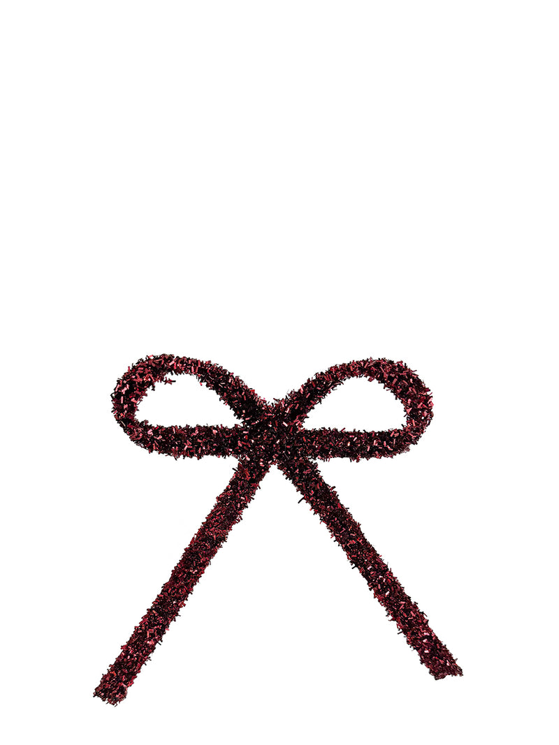 A decorative bow made from dark burgundy glittery tinsel, isolated on a solid white background.