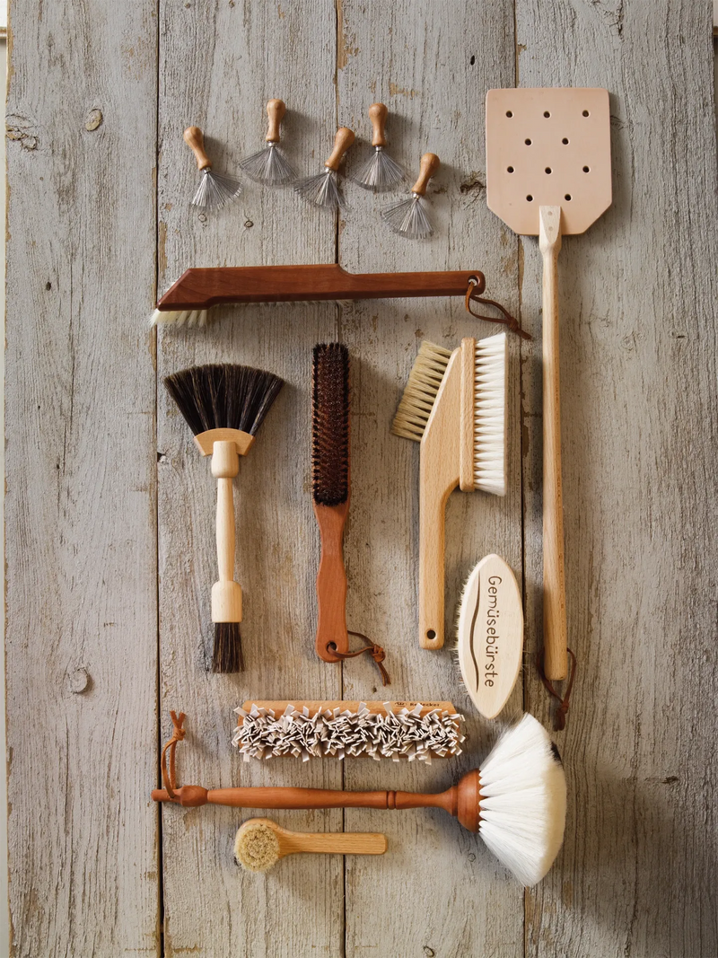 Set of cleaning brushes and tools on a wooden surface