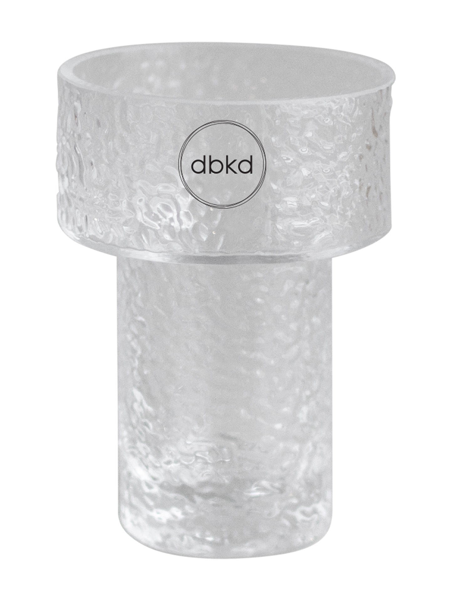 A clear textured glass vessel with a wide top rim and a cylindrical base, featuring a circular logo in the center that reads 'dbkd'.